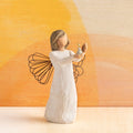Willow Tree Angel of Hope, 5.5"h hand-painted standing resin figure in cream dress with wire wings, holding candle with gold-leaf flame in hands, in front of orange painting