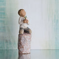 Willow Tree something special, 5.5”h hand-painted figure of small boy holding plant in pot, kneeling on tall rock etched with nature imagery, in front of grey painting