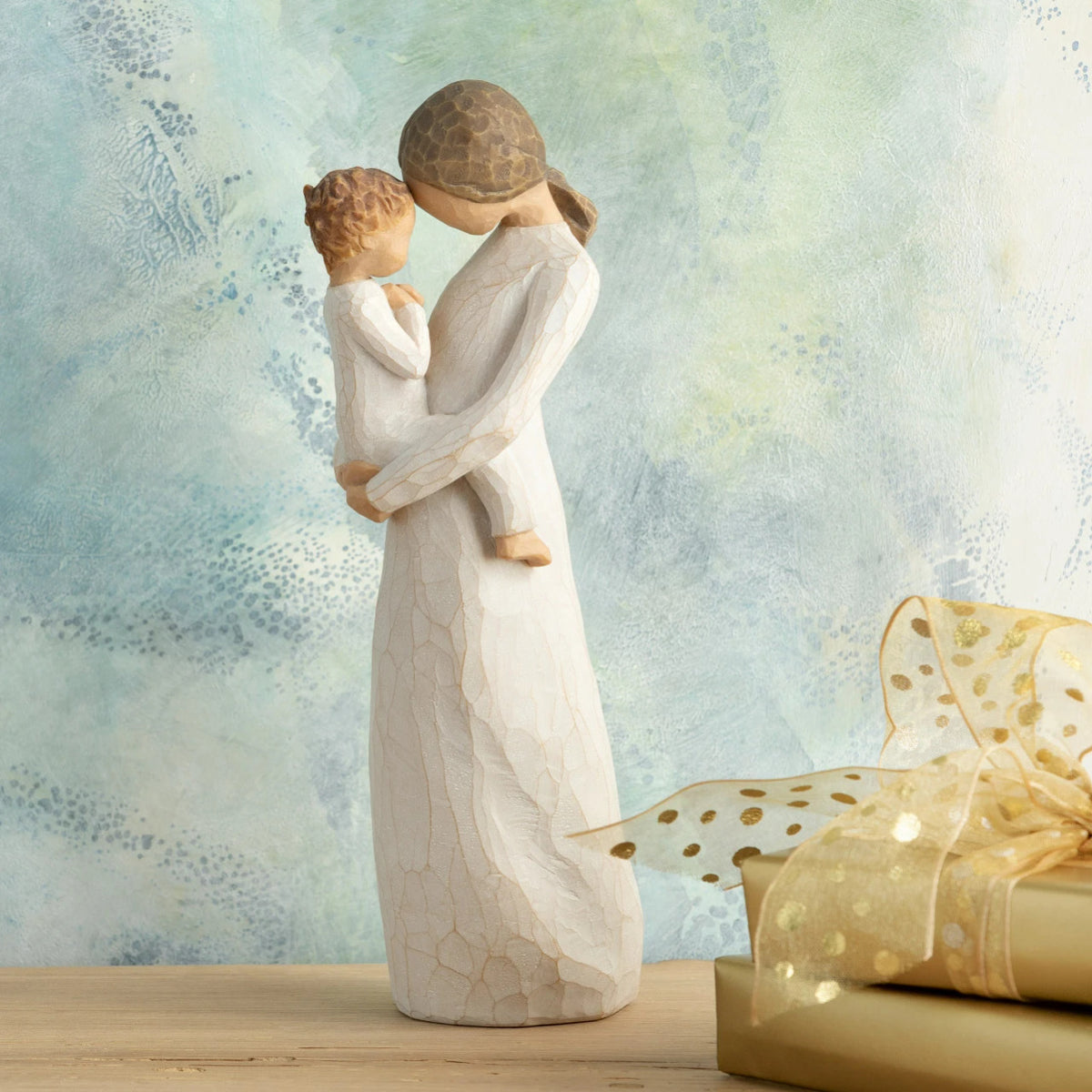 Willow Tree Tenderness, 8”h hand-painted standing resin figure holding toddler, foreheads touching, both dressed in cream, in front of blue painting
