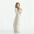 Faceless mother figurine wearing white dress holding baby to her neck