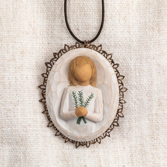 Oval bas-relief carving of figure holding sprig of rosemary, edged in pierced-metal filigree with brown elastic ornament loop