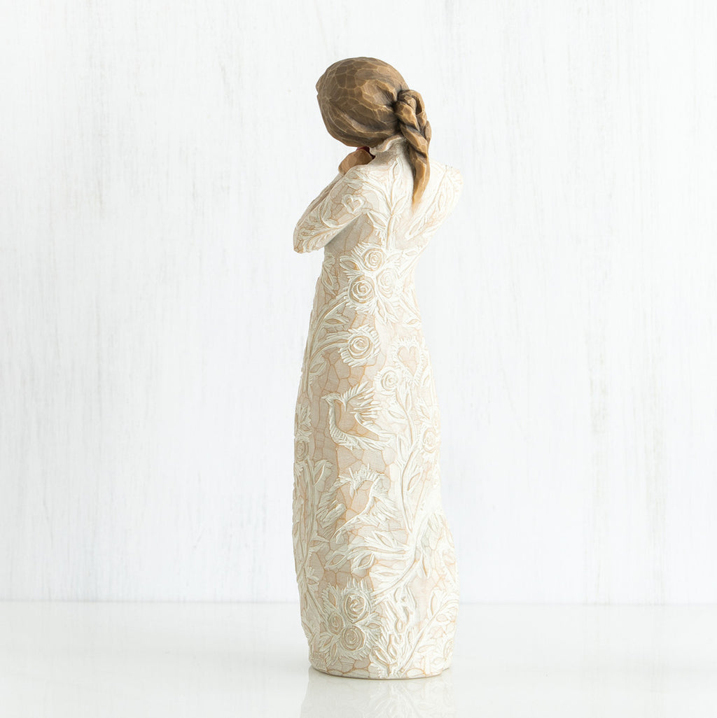 Side view of younger girl brunette figurine wearing white dress facing the other side