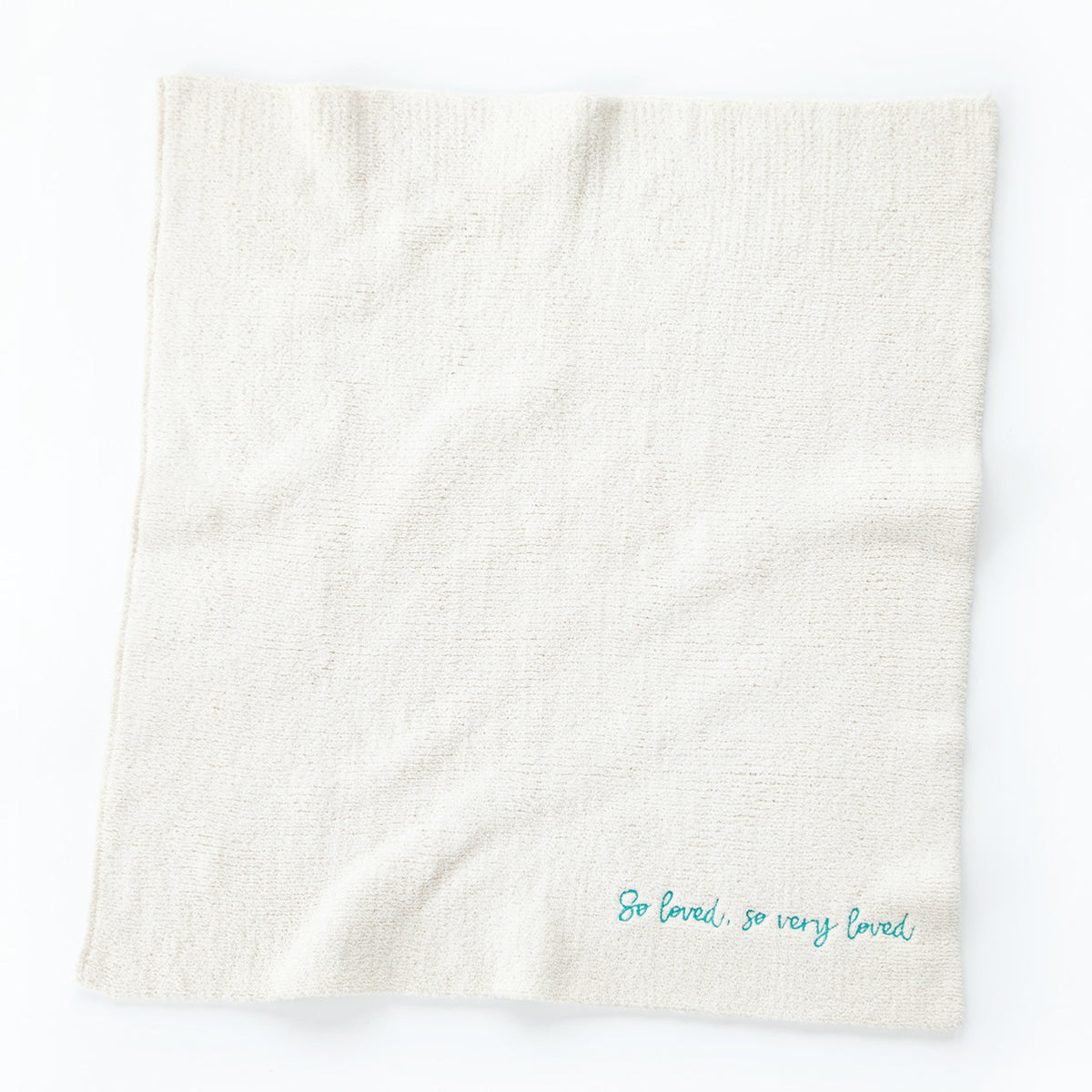 Overview of white towel with 'so loved, so very loved' in light blue in the right corner