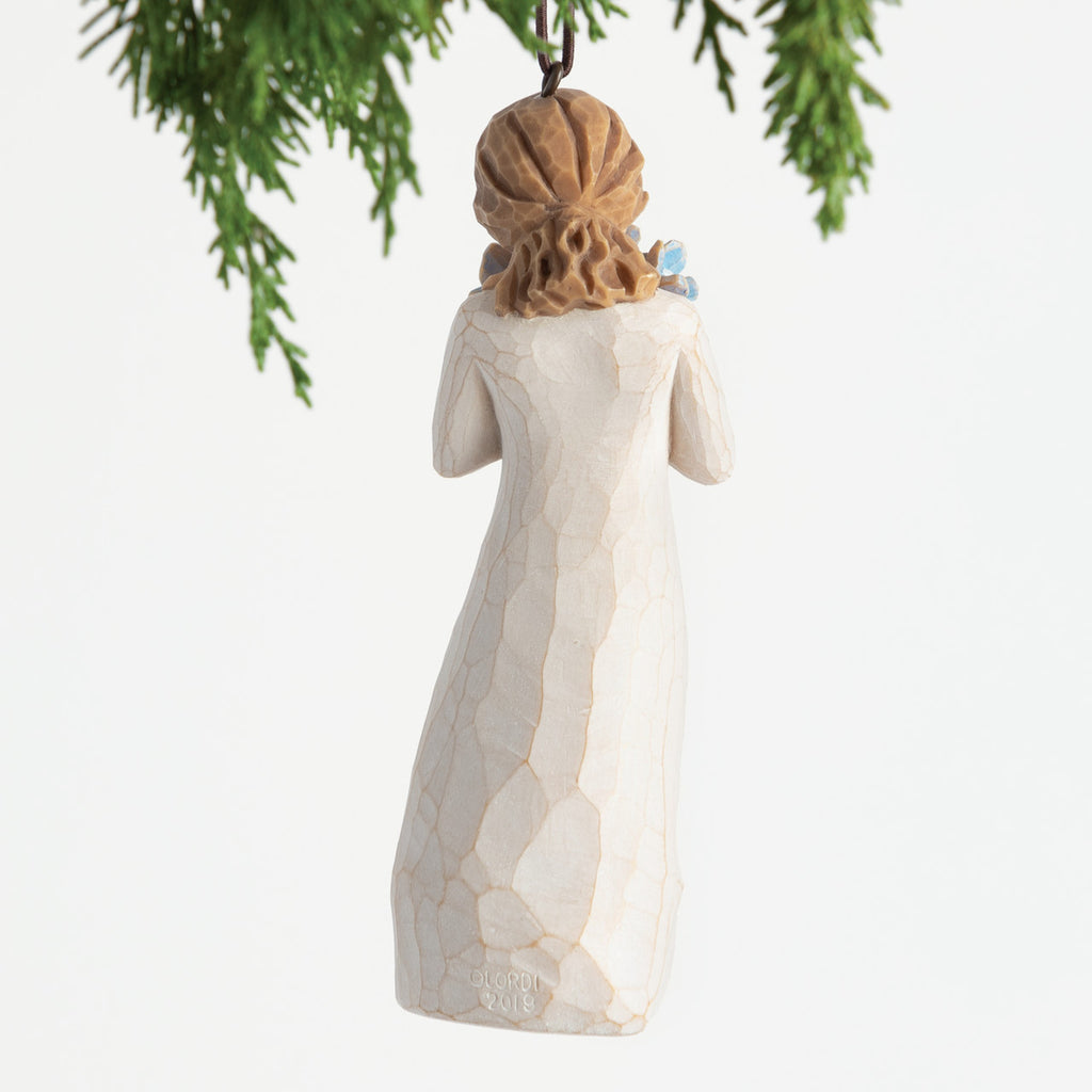 Back view, female figure in cream dress, holding bouquet of blue forget-me-not flowers to face. Hook and loop affixed to head