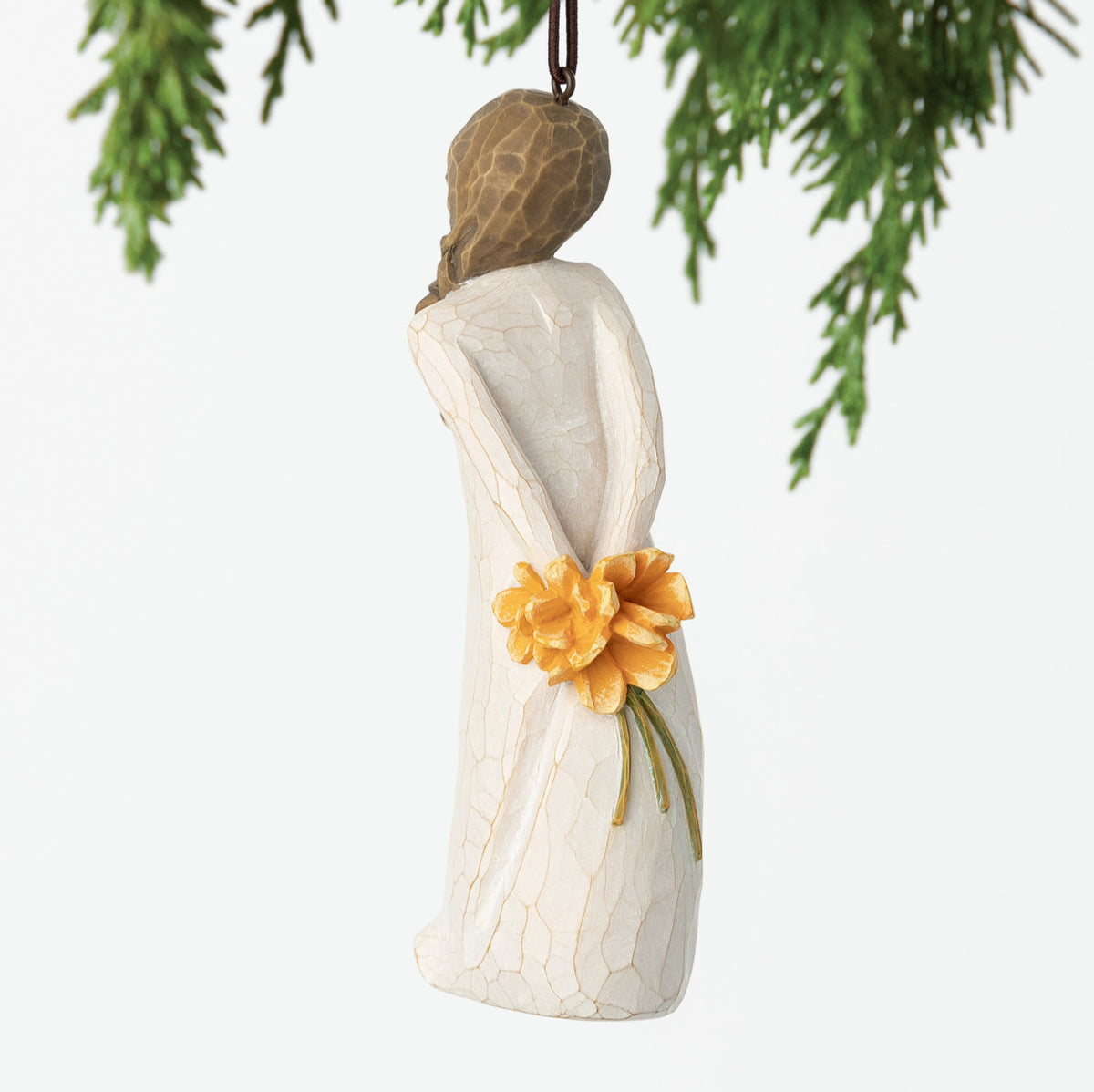 Back view, female figure in cream dress, holding bouquet of orange flowers behind back. Hook and loop affixed to head