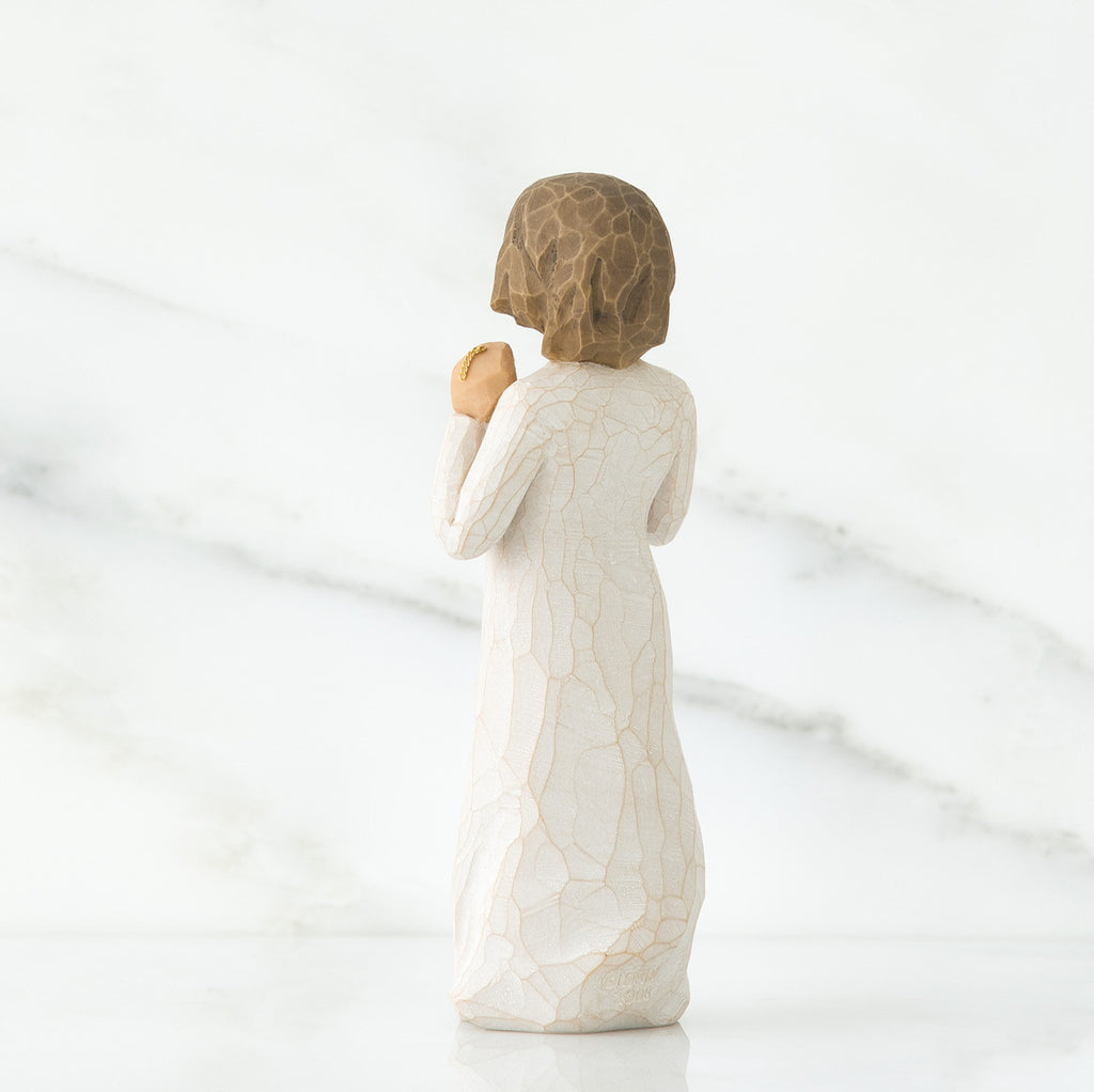 Back view of brunette girl figurine in white dress
