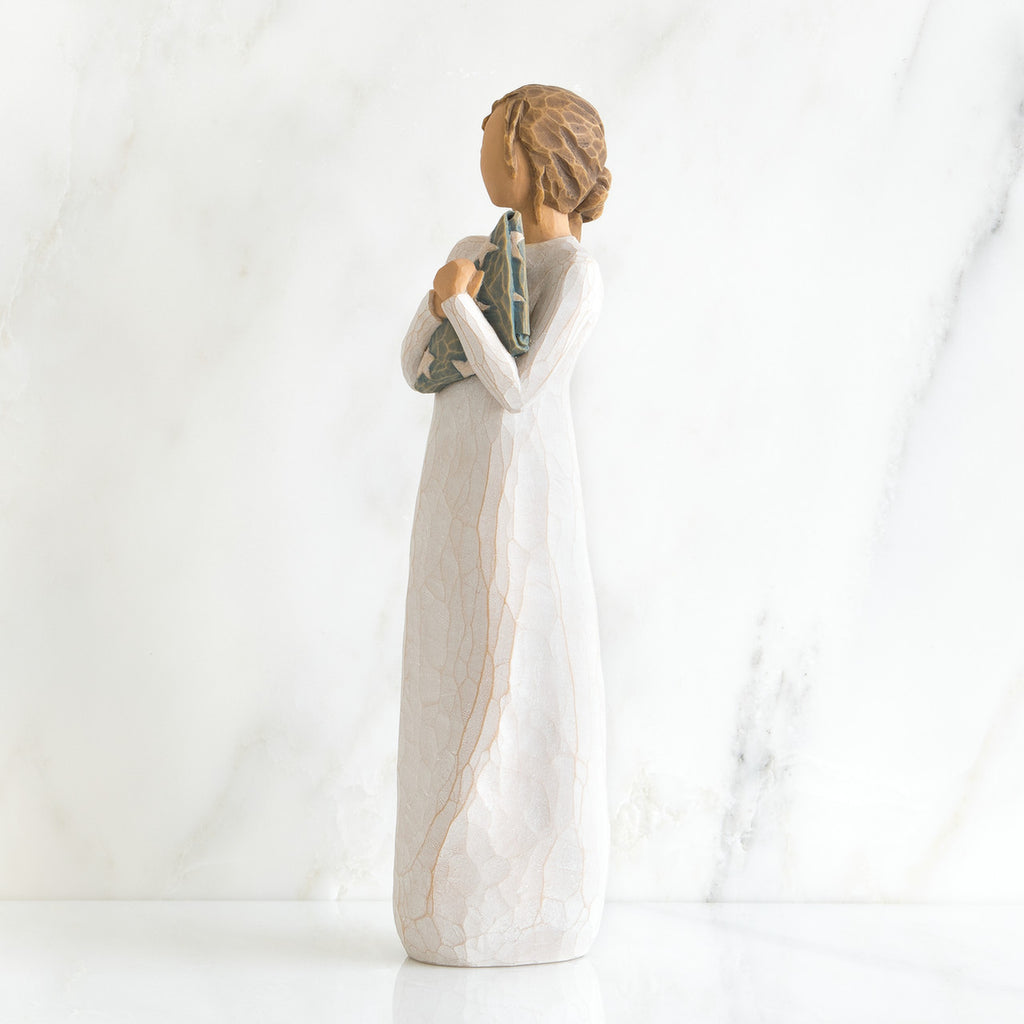 Side view of brunette girl figurine in white dress holding triangle figurine