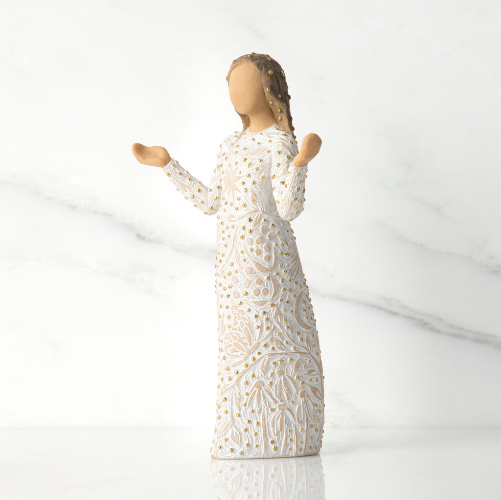 Side view of brunette girl figurine in white dress with gold dots holding her hands up