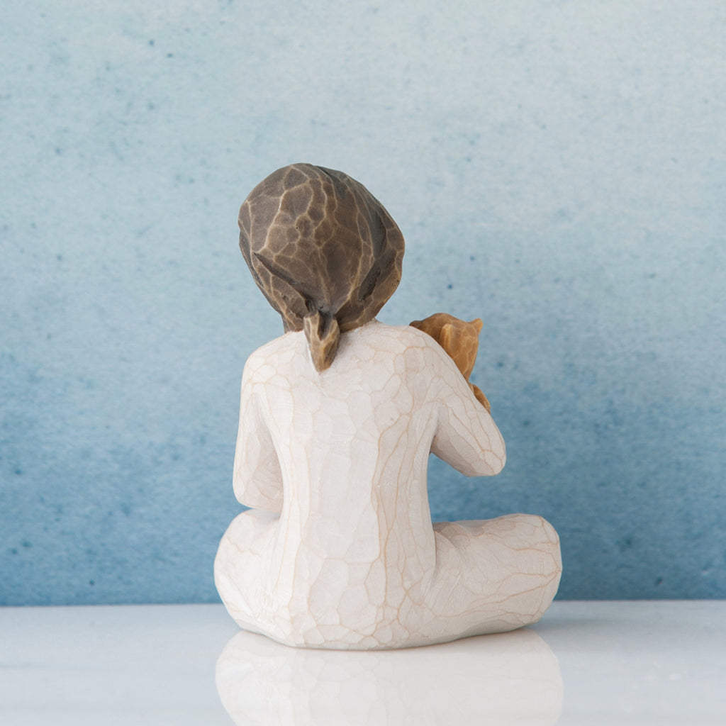 Small brunette girl in white facing away from the front towards the blue wall