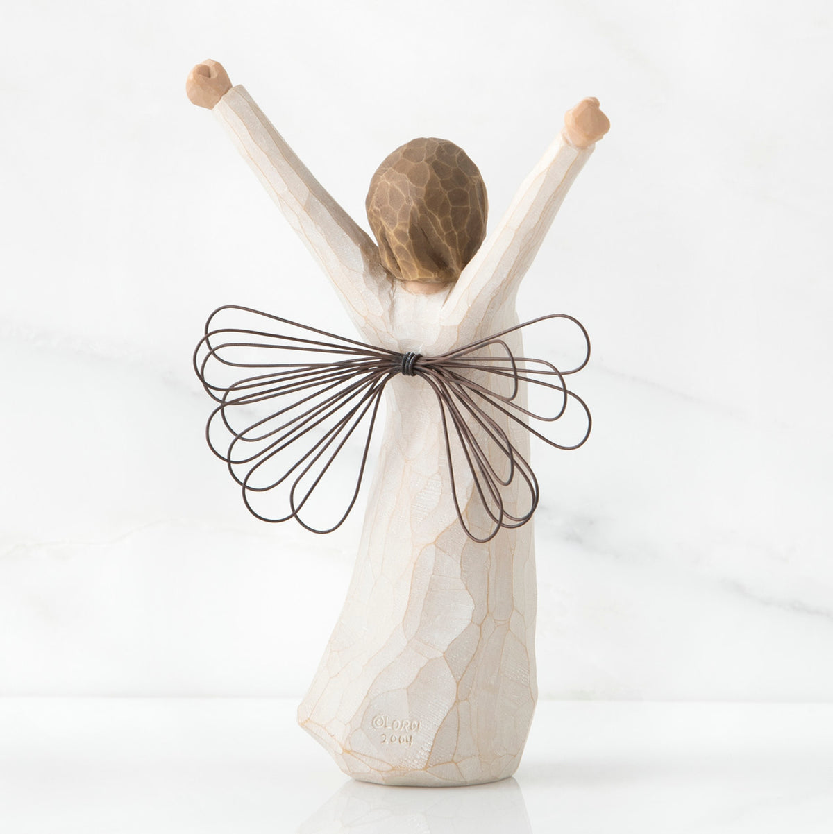 Back view of brunette angel figurine in white dress with brown wire wings