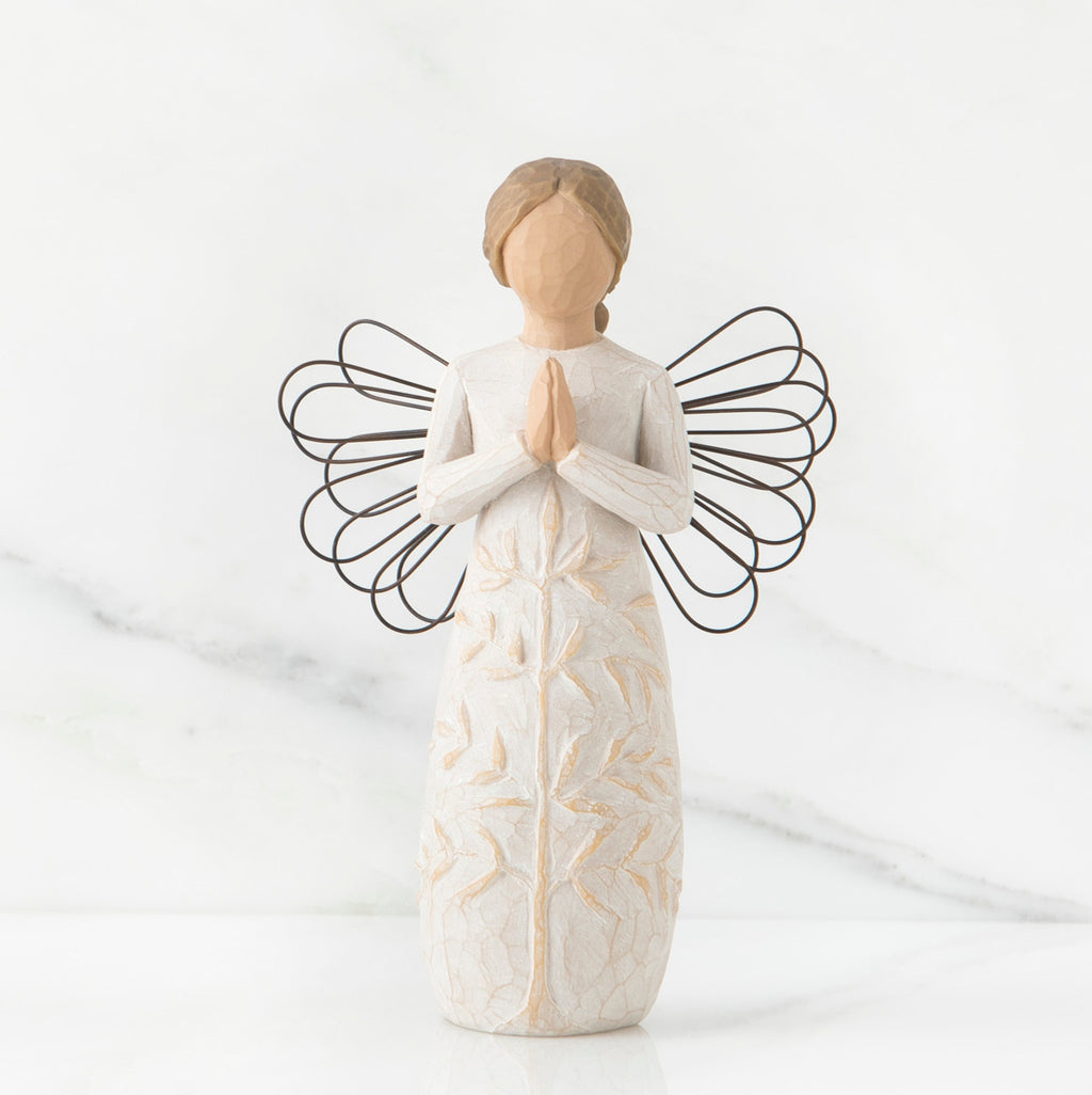 Faceless woman figurine in white dress with black wire angel wings - her hands are folded in prayer form