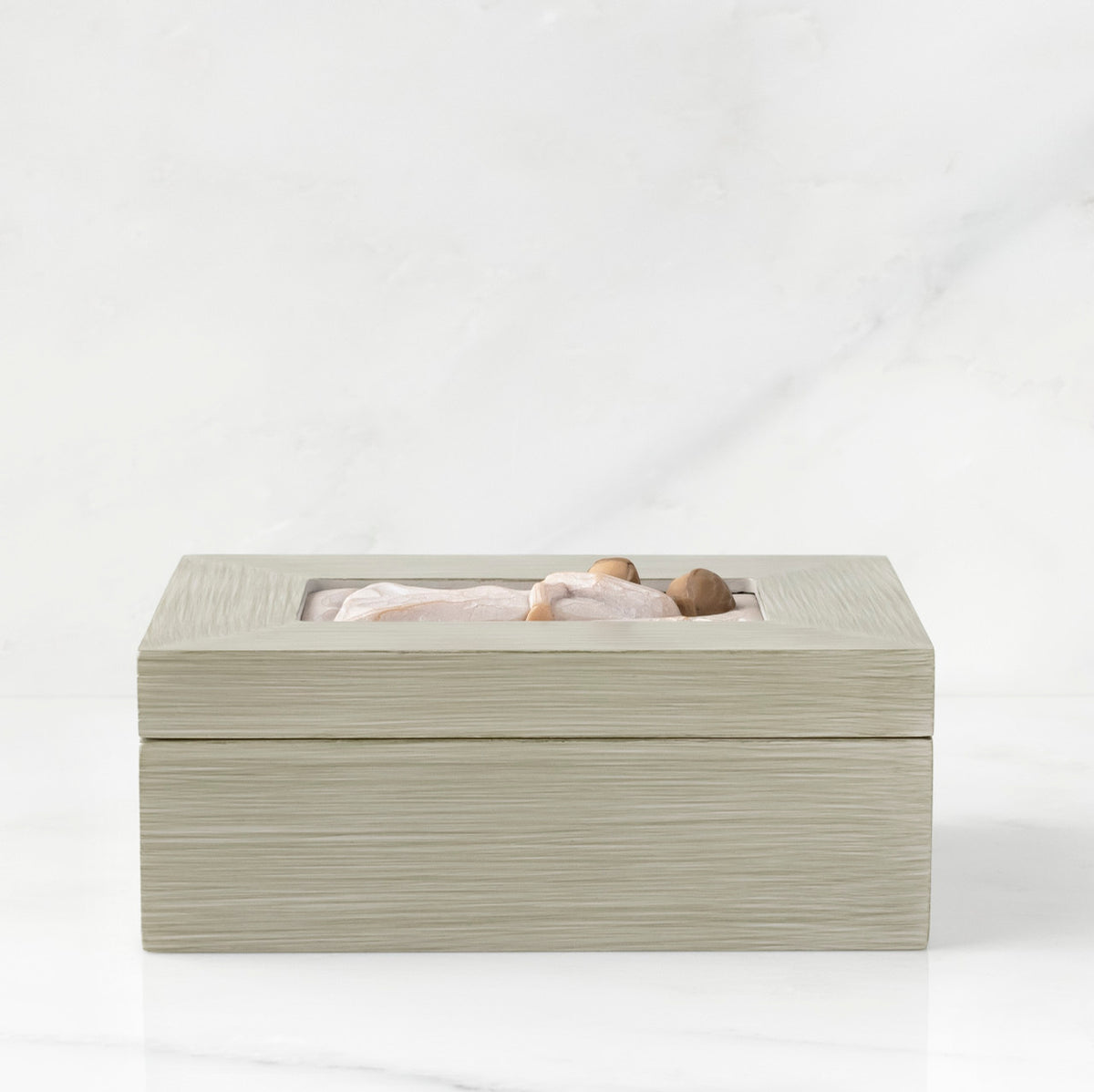 Side view: Light gray rectangular wood box with hinged lid, carving on lid of female and child embracing in cream dresses