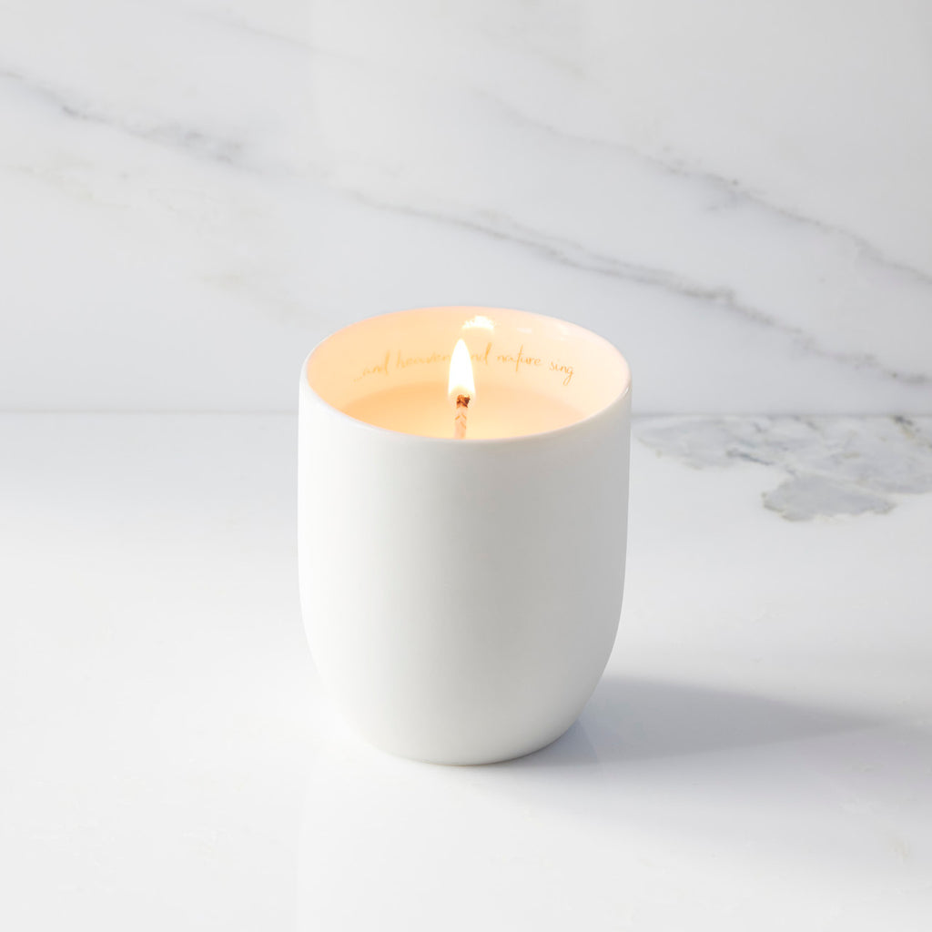Lit filled scented candle with unglazed cream tapered cylinder vessel, sentiment written in gold inside rim, plant-based wax blend, all-cotton wick