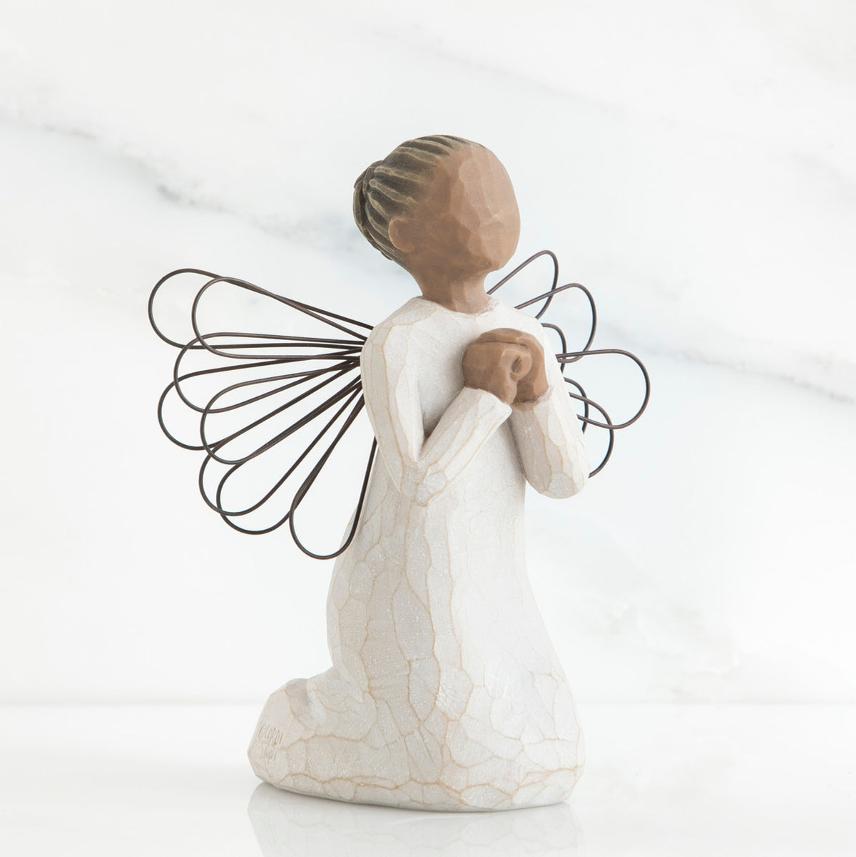 Faceless young girl figurine kneeling praying in white dress - she has black wire wings