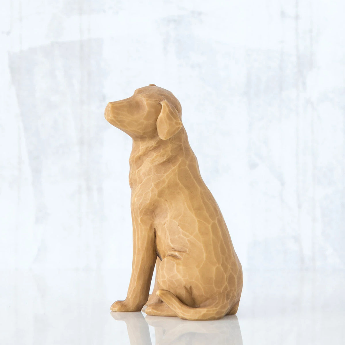 Golden dog figurine sitting to the side - all white background