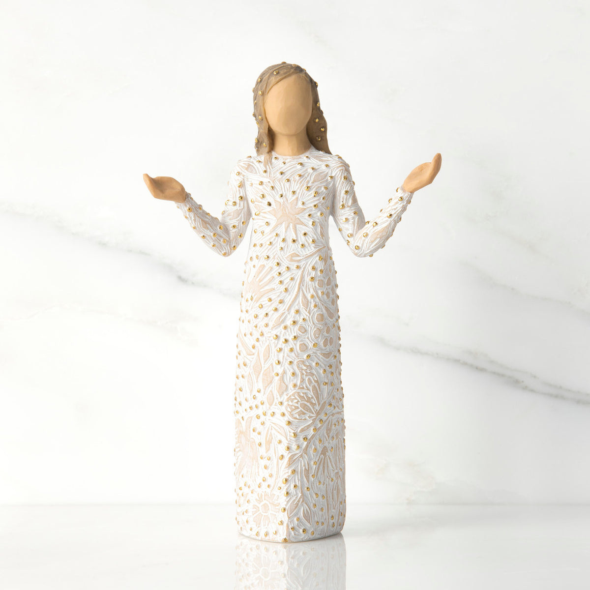 Front view of brunette girl figurine in white dress with gold dots holding her hands to the side