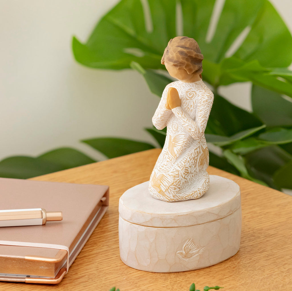 Willow Tree Prayer of Peace Keepsake Box, 3.5"oval hand-painted resin box with 3”H kneeling figure in cream dress carved with nature imagery, in prayer/meditation pose, affixed to lid, on desk